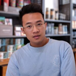 man wearing eyeglasses and blue shirt inside coffee shop